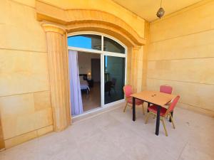 a dining room with a table and chairs and a window at Stay Room Jumeriah Dubai in Dubai