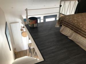 a bedroom with a bed and a mirror next to it at Cosy Studio Mezzanine 2 personnes Plage de Mardi Gras le Vieil in Le Grand Vieil