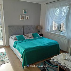Un dormitorio con una cama con una manta verde. en Villa Turkus, en Jastrzębia Góra