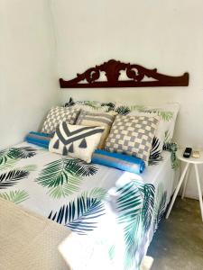 Schlafzimmer mit einem Bett mit tropischen Drucken in der Unterkunft Suíte - 05 in Gravatá