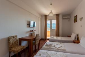 a room with two beds and a desk and a window at Evropa Lux Apartments in Budva