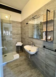 een badkamer met een wastafel, een douche en een spiegel bij La Piramide in Manarola