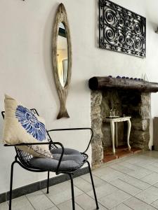 einen Stuhl mit einem Kissen und einem Spiegel in einem Zimmer in der Unterkunft La Piramide in Manarola