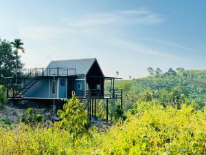 une maison bleue sur le côté d'une colline dans l'établissement เขากิวเทอเรส @สิชล, à Sichon