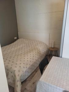 um pequeno quarto com 2 camas e uma mesa em Vallholt em Selfoss