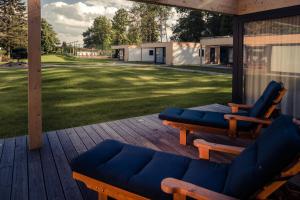 a porch with two blue chairs and a couch at Villa Resort & Organic Spa in České Budějovice