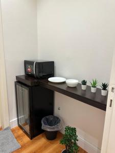 a table with a microwave and some plants on it at شقة أنيقة في حي النزهه in Riyadh