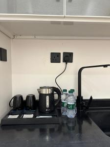 a stove top with a pot and two water bottles at شقة أنيقة في حي النزهه in Riyadh
