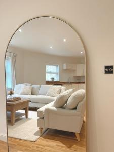a living room with a white couch and a mirror at Yarm Luxury Apartments - Bank House - private gated carpark in Stockton-on-Tees