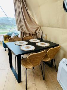 una mesa negra con sillas y platos. en IdyllaGlamp- Glamping Boho, en Dzbądzek