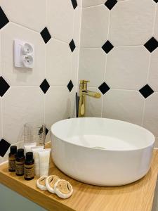 a bathroom with a white sink and black and white tiles at IdyllaGlamp- Glamping Boho in Dzbądzek +26 photos