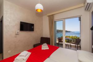a bedroom with a red bed with a view of the ocean at David Lux beach rooms in Dobra Voda