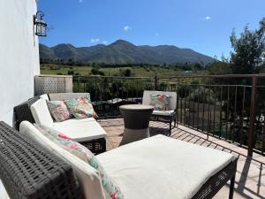a balcony with two chairs and a table with mountains in the background at Paradise View - Lauro Golf in Alhaurín de la Torre