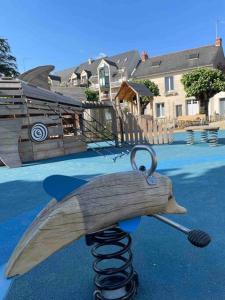 a wooden toy shark on a slide in a playground at Joli studio au calme en bord de mer #pornichouette in Pornichet