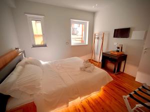 a bedroom with a white bed and a table at Taormina Boutique Rooms in Taormina