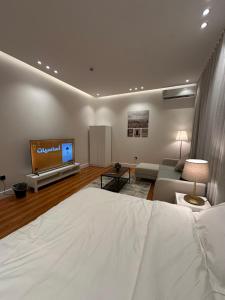 um quarto com uma cama e uma televisão de ecrã plano em شقة أنيقة في حي النزهه em Riyadh