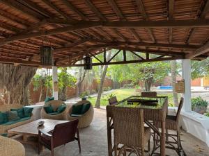 コトヌーにあるMaison-Villa de charme à Cotonouの木製パーゴラの下にテーブルと椅子が備わるパティオ