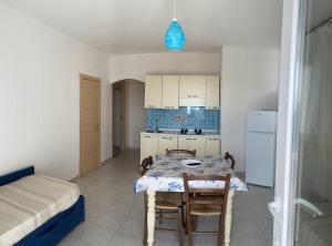 a room with a table and a kitchen with a bed at Borgo del Tennis - Sa Ventana 2 in Badesi