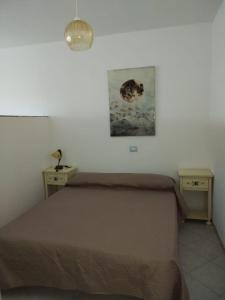 a bedroom with a bed and two night tables and a picture at Borgo del Tennis - Sa Ventana 2 in Badesi