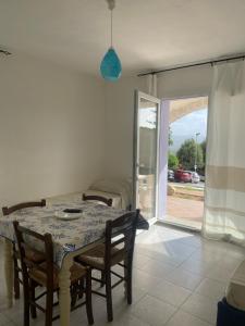 a dining room with a table and chairs and a window at Borgo del Tennis - Sa Ventana 2 in Badesi