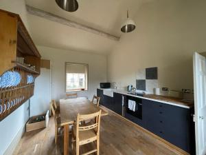uma cozinha com uma mesa de madeira e uma sala de jantar em Apartment at Llanerchydol Hall em Welshpool