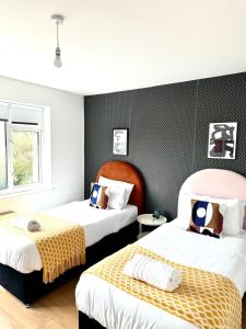 two beds in a room with black and white at Deluxe Beach House in Brighton & Hove