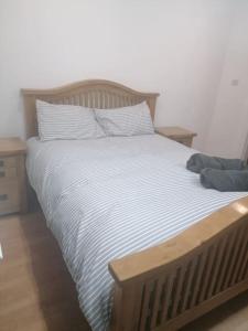 a large bed with a wooden headboard and pillows at Stunning 4 Bed Exclusive Queens Quarter Luxury Beside City Centre in Belfast