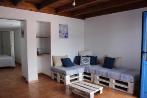 een woonkamer met een bank en blauwe kussens bij Casa Noah Famara in Famara