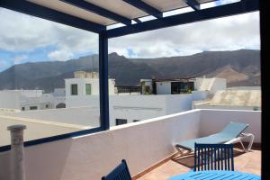 balcón con sillas y vistas a las montañas en Casa Noah Famara, en Famara