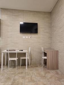 ein Esszimmer mit einem Tisch und einem TV an der Wand in der Unterkunft Milano Vimodrone Appartamento Il nido in Vimodrone
