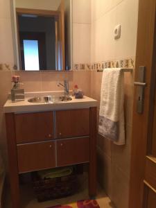 ein Bad mit einem Waschbecken und einem Spiegel in der Unterkunft Your place in Faro in Faro