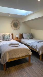 1 dormitorio con 2 camas y espejo en la pared en City Centre Bridge Street Apartment en Kirkwall