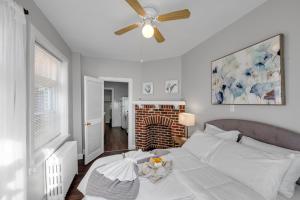 a white bedroom with a bed and a ceiling fan at Univ City Upenndrexel 2 Bdrm Lovely Unit in Philadelphia
