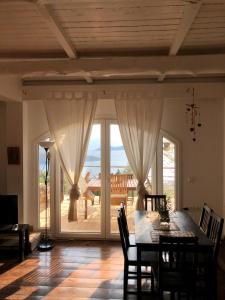 a dining room with a table and a large sliding glass door at Melolia Estate in Thiva