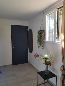 a room with a black door and a table with flowers at Logement de charme et confort in Sceaux