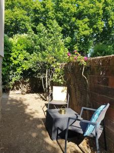 a patio with a table and chairs next to a wall at Logement de charme et confort in Sceaux