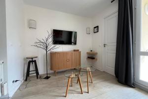 ein Wohnzimmer mit einem TV an einer weißen Wand in der Unterkunft Beautiful flat with swimming pool tennis court and private car parking REF 109 in Le Touquet-Paris-Plage