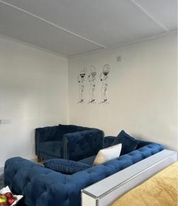 una sala de estar con 2 sofás azules y una pintura en Jomana Luxury Apartments, en Lusaka