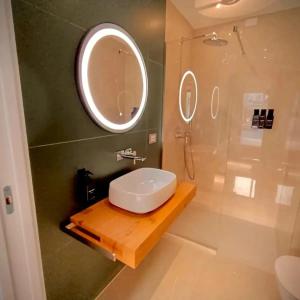 a bathroom with a sink and a shower with a mirror at Taormina Boutique Rooms in Taormina