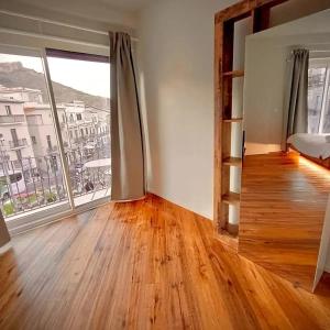 an empty room with a large window and wooden floors at Taormina Boutique Rooms in Taormina