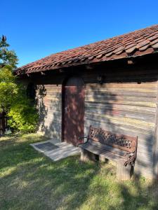 a wooden bench in front of a building at Łęgowska Dolina in Olecko