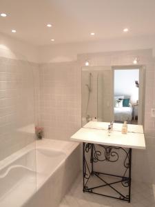a bathroom with a sink and a tub and a mirror at Evian villa with Lake Geneva views in 1960 mid-century modern style in Neuvecelle +46 photos