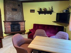 a living room with a table and chairs and a fireplace at Łęgowska Dolina in Olecko