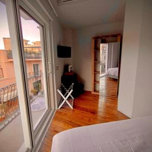 ein Schlafzimmer mit einem großen Fenster und ein Zimmer mit einem Bett in der Unterkunft Taormina Boutique Rooms in Taormina