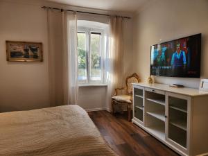 a bedroom with a bed and a flat screen tv at Villa Marina Izola - Free Parking in Izola