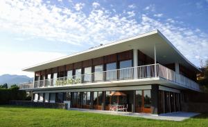 a large building with a balcony on top of it at Evian villa with Lake Geneva views in 1960 mid-century modern style in Neuvecelle
