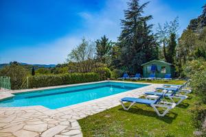 een zwembad met ligstoelen en een huis bij Exclusive Villa in Provence with swimming pool in a very quiet private domain in Montauroux
