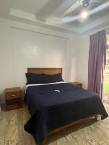 Un dormitorio con una cama azul y una ventana en Hotel Costa Linda Beach Boca Chica en Boca Chica