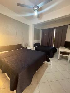1 dormitorio con 1 cama y ventilador de techo en Hotel Costa Linda Beach Boca Chica en Boca Chica
