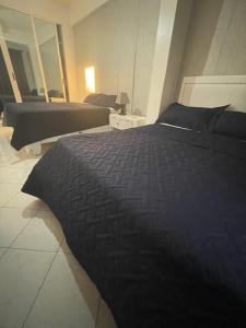 a bedroom with two beds and a black blanket at Hotel Costa Linda Beach Boca Chica in Boca Chica